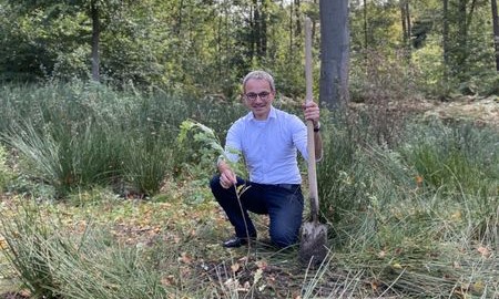 Bundestagsabgeordneter Oellers pflanzt Setzling in Nachhaltigkeitswoche